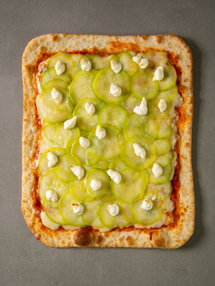 Pizza Romana Crocante Abobrinha com Requeijão congelada vista de cima, com lâminas de abobrinha e pontos de requeijão