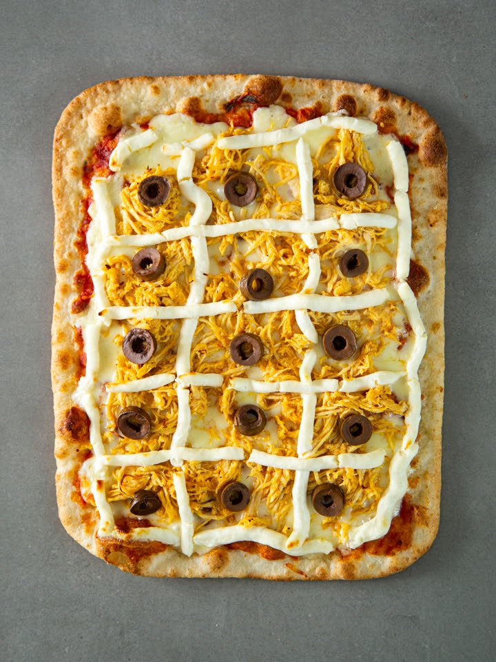 Pizza Romana Crocante Frango com Requeijão congelada vista de cima, com frango desfiado, requeijão em treliça e azeitonas pretas