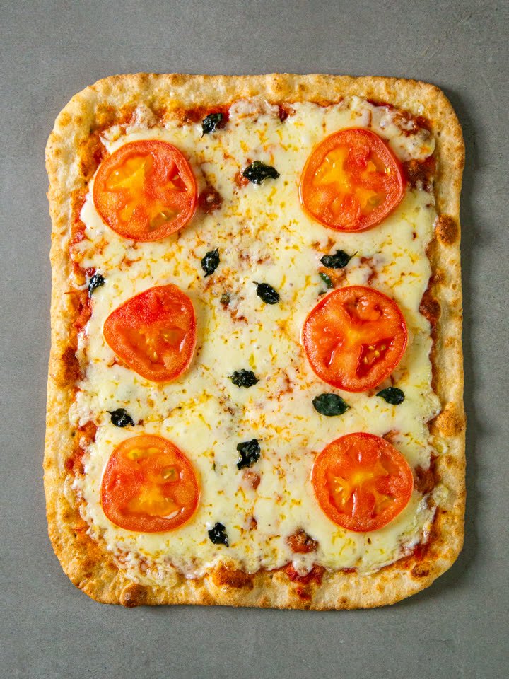 Pizza Romana Crocante Marguerita congelada vista de cima, com muçarela, rodelas de tomate e manjericão